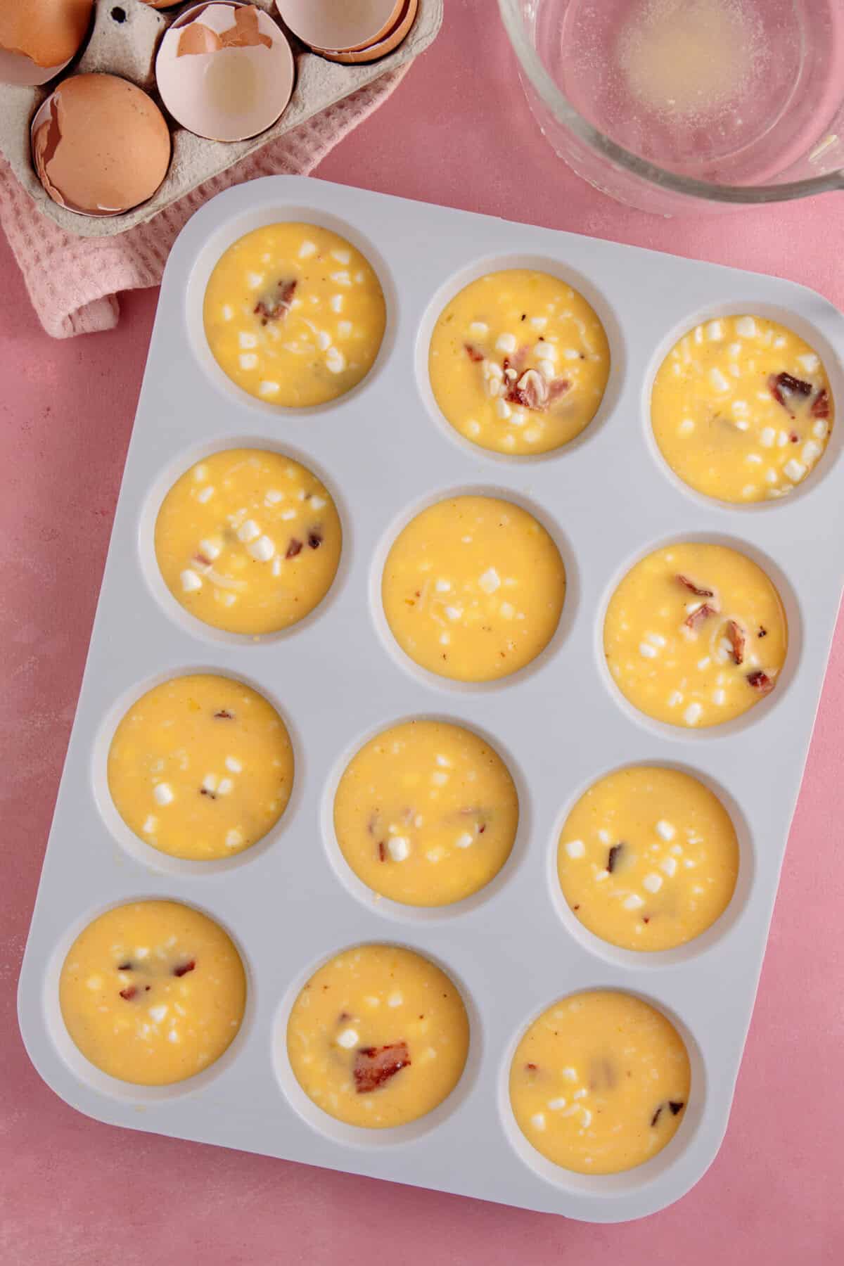 Process shot of cottage cheese egg bites recipe showing the mixture in the muffin tin before baking.