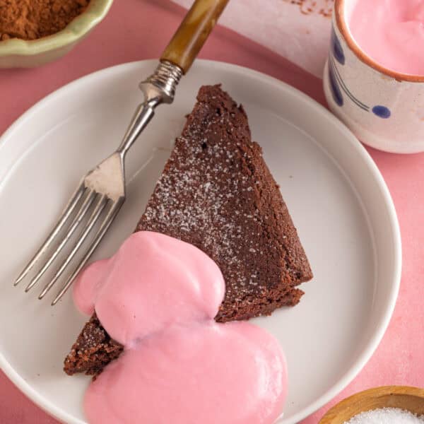 A slice of chocolate concrete with pink custard.