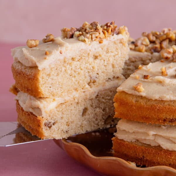 A slice of gluten free coffee and walnut cake being served up.