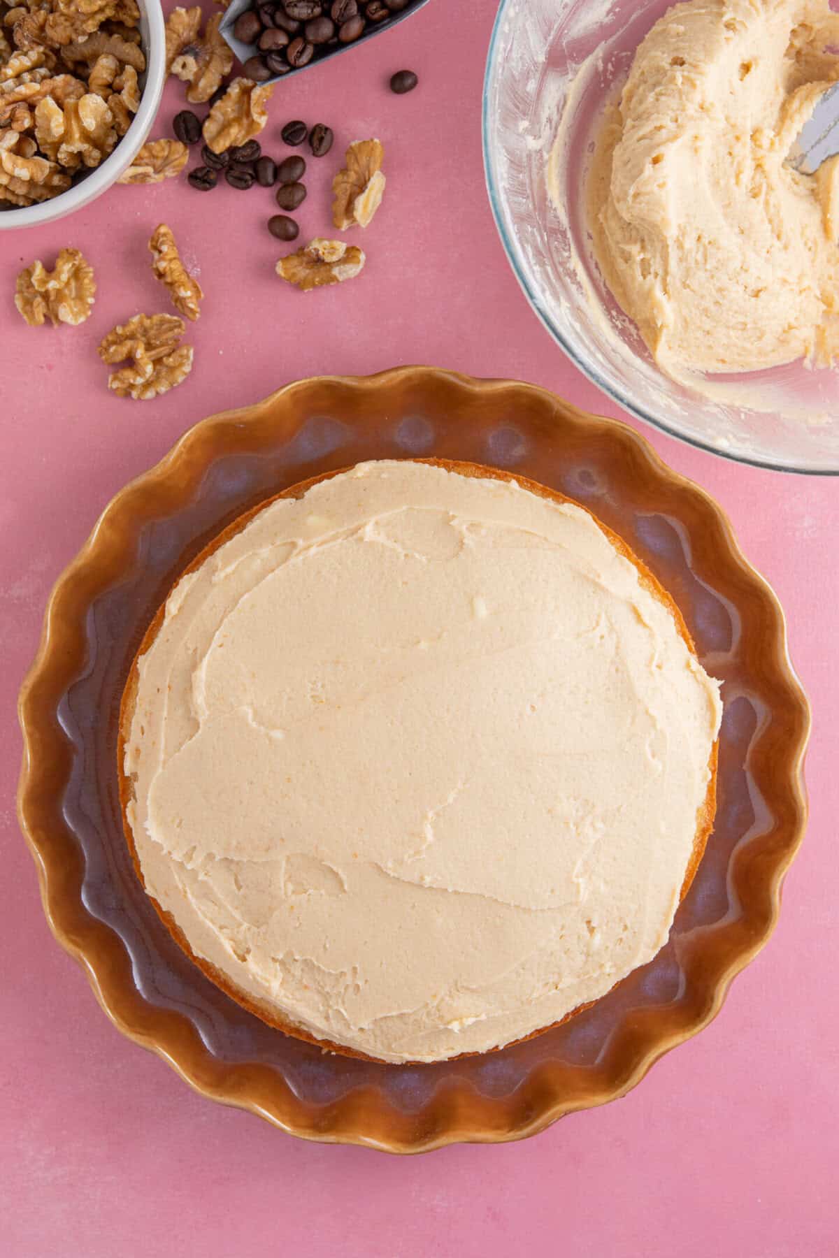 Process shot for gluten free coffee and walnut cake showing the cake being assembled and decorated.