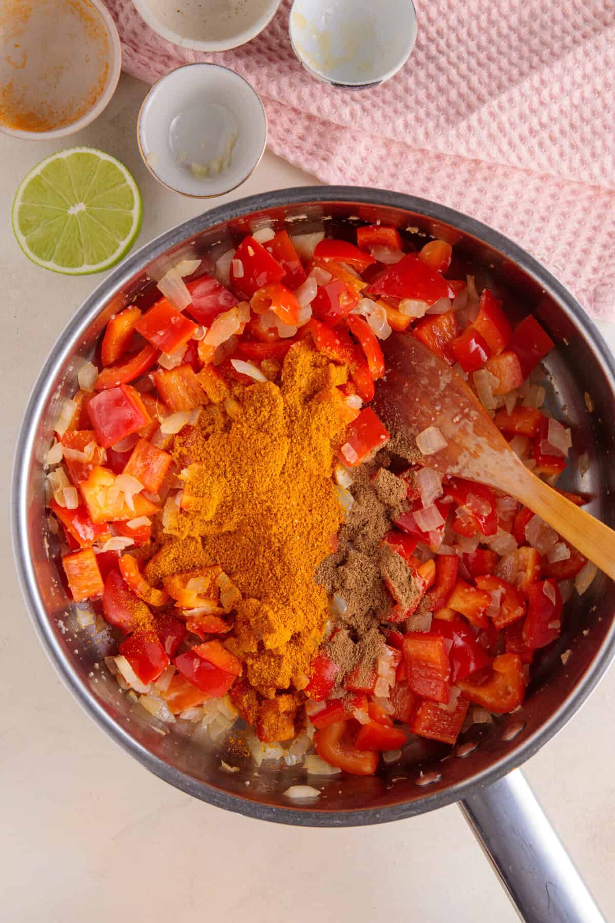 Process shot for halloumi curry showing the spices added to the frying vegetables.