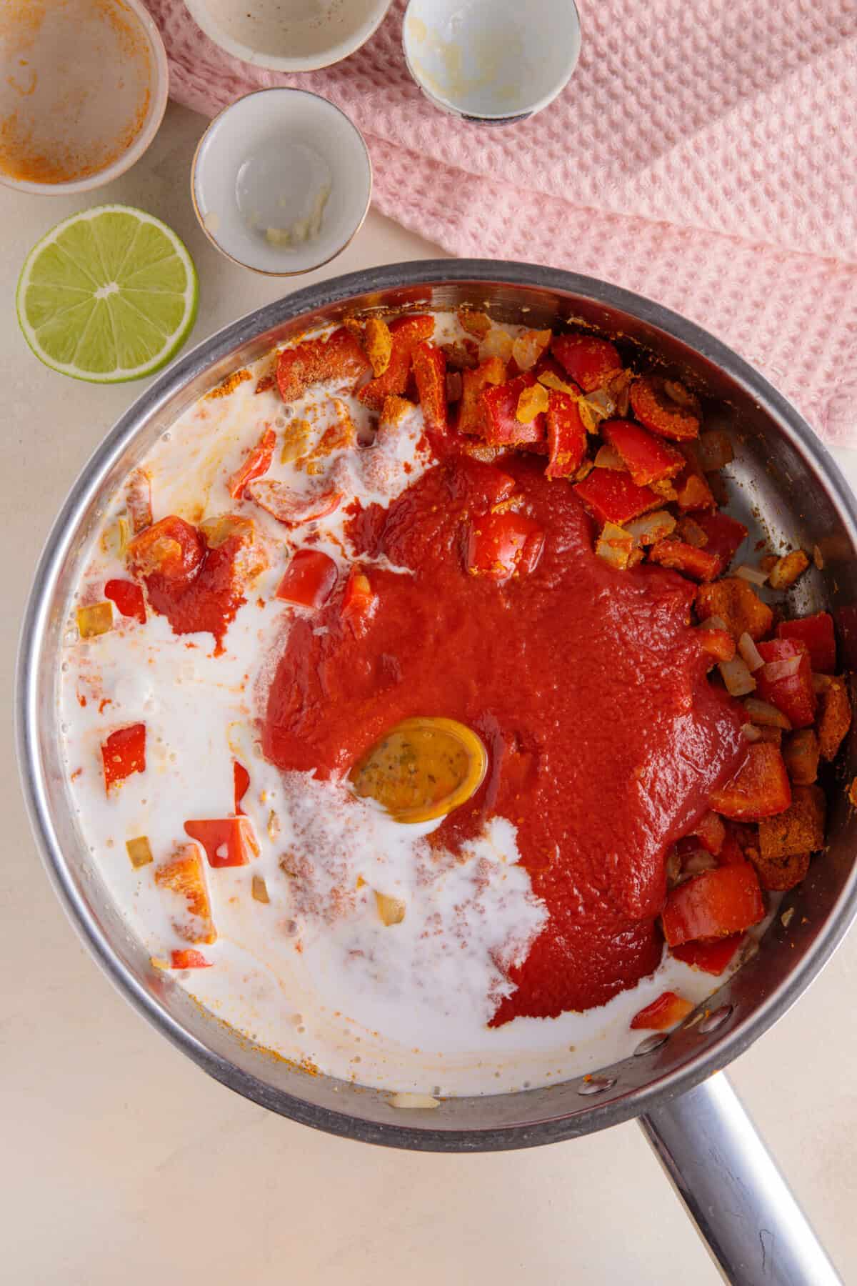 Process shot for halloumi curry showing the passata and coconut milk added to the pan.