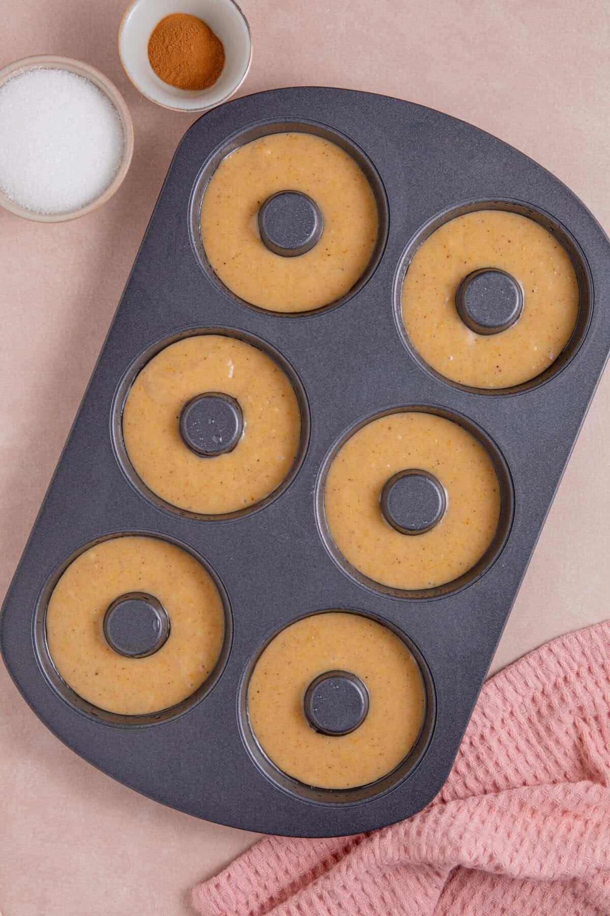 Process shots for gluten free pumpkin donuts recipe showing the batter in the donut tin.