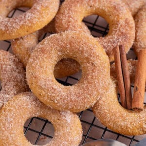 Close up of a pile of pumpkin donuts with cinnamon sugar.