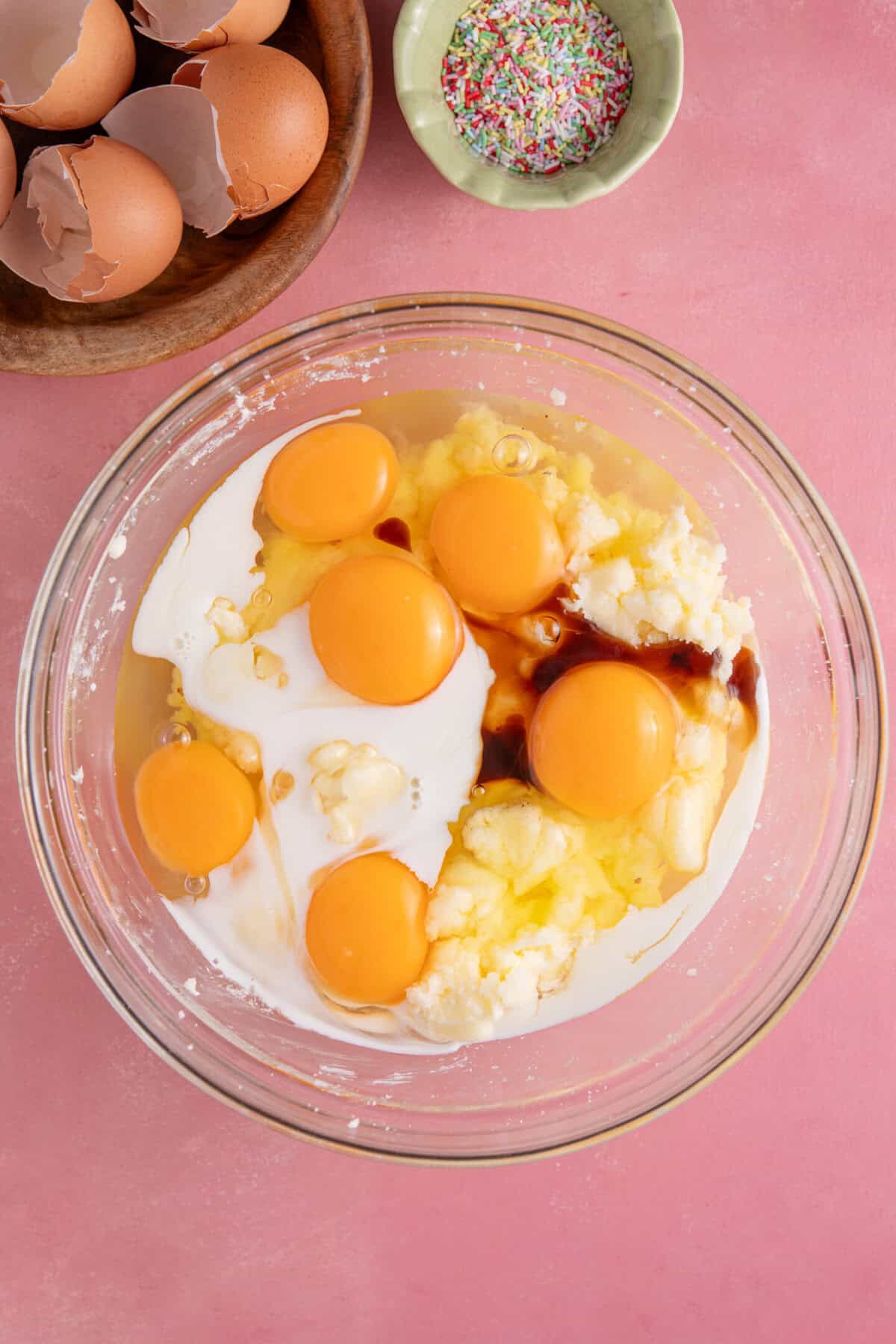 Process shot for gluten free school dinner cake showing the eggs, butter and sugar in a mixing bowl.