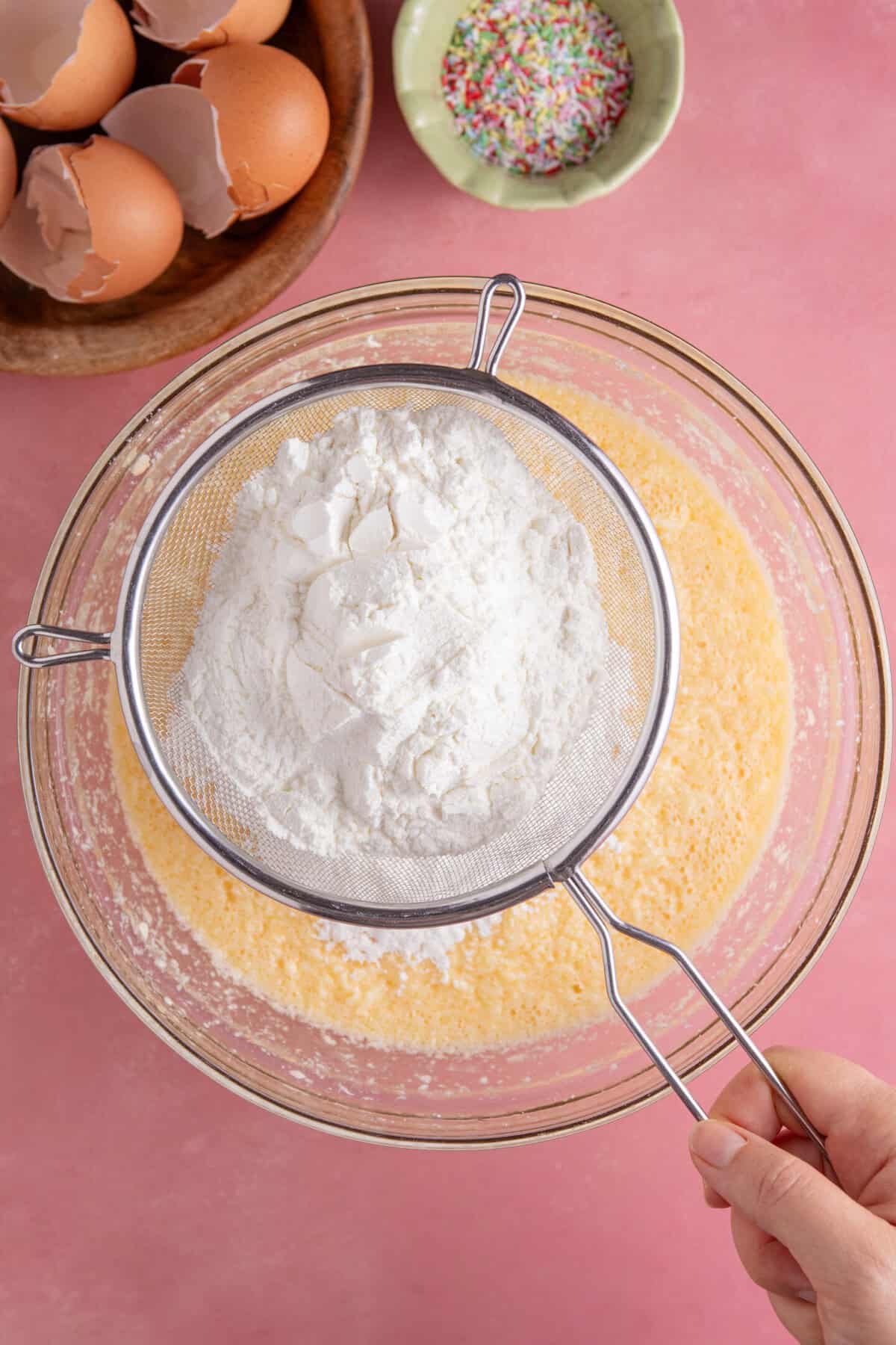 Process shot for gluten free school dinner cake showing the dry ingredients added to the wet ones.