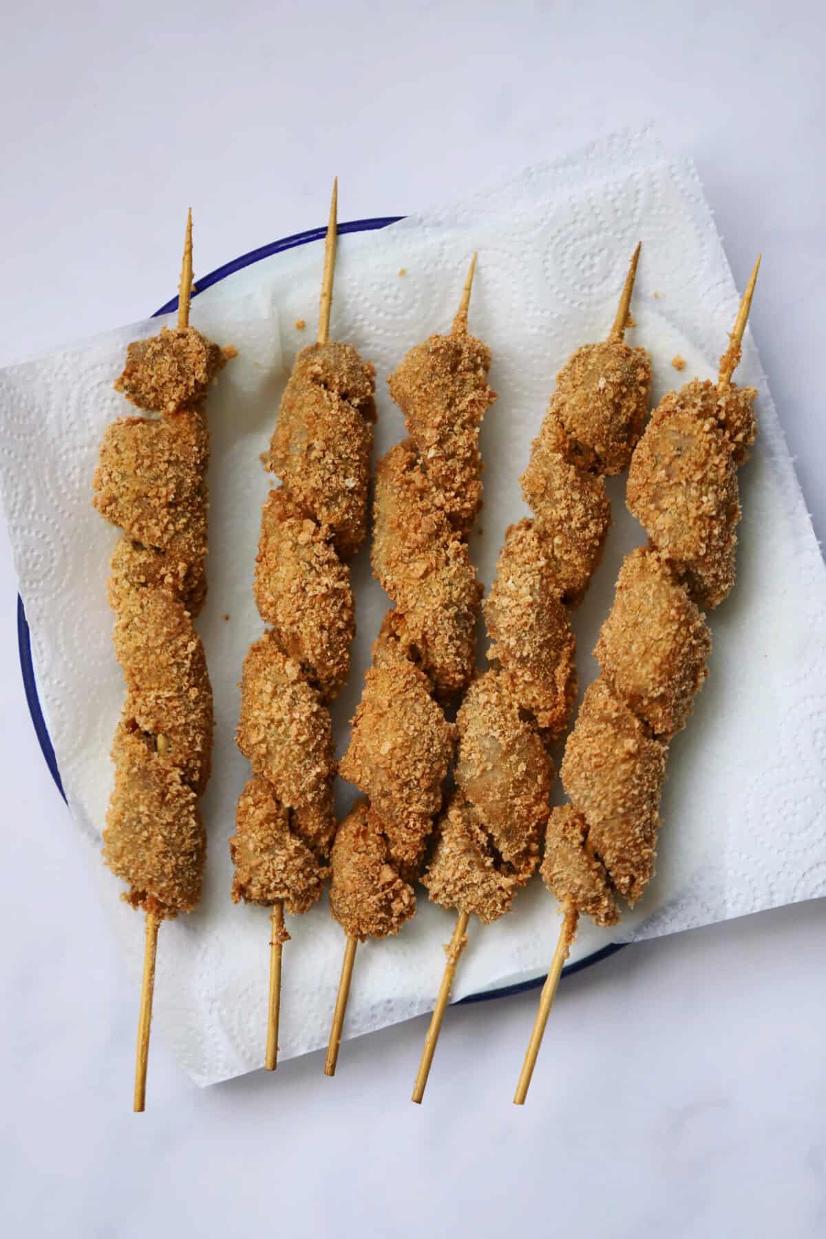 Process shot of gluten free turkey twizzlers showing a plate of turkey twizzlers on a sheet of kitchen towel.