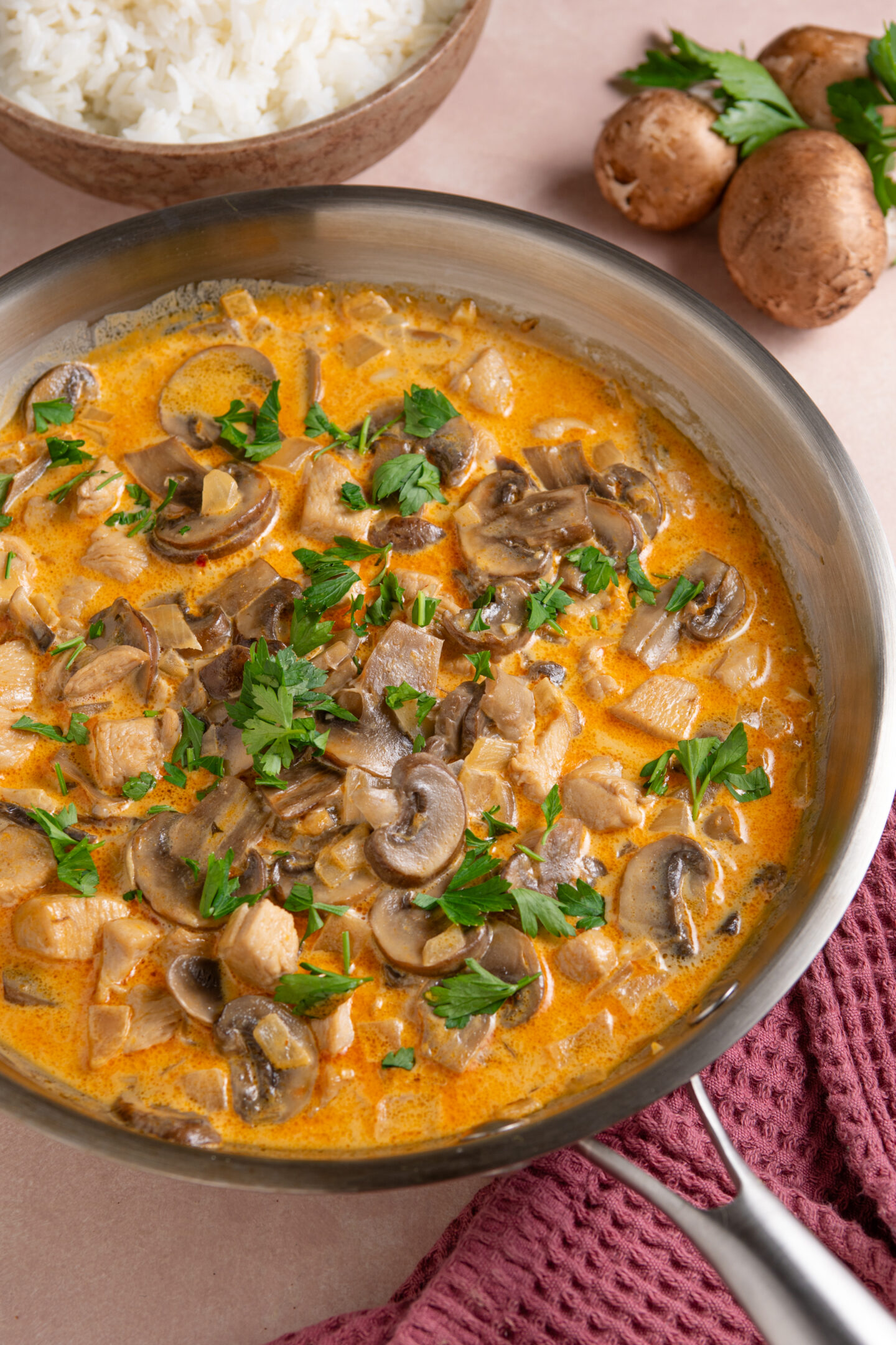 A pan of chicken stroganoff garnished with fresh parsley.