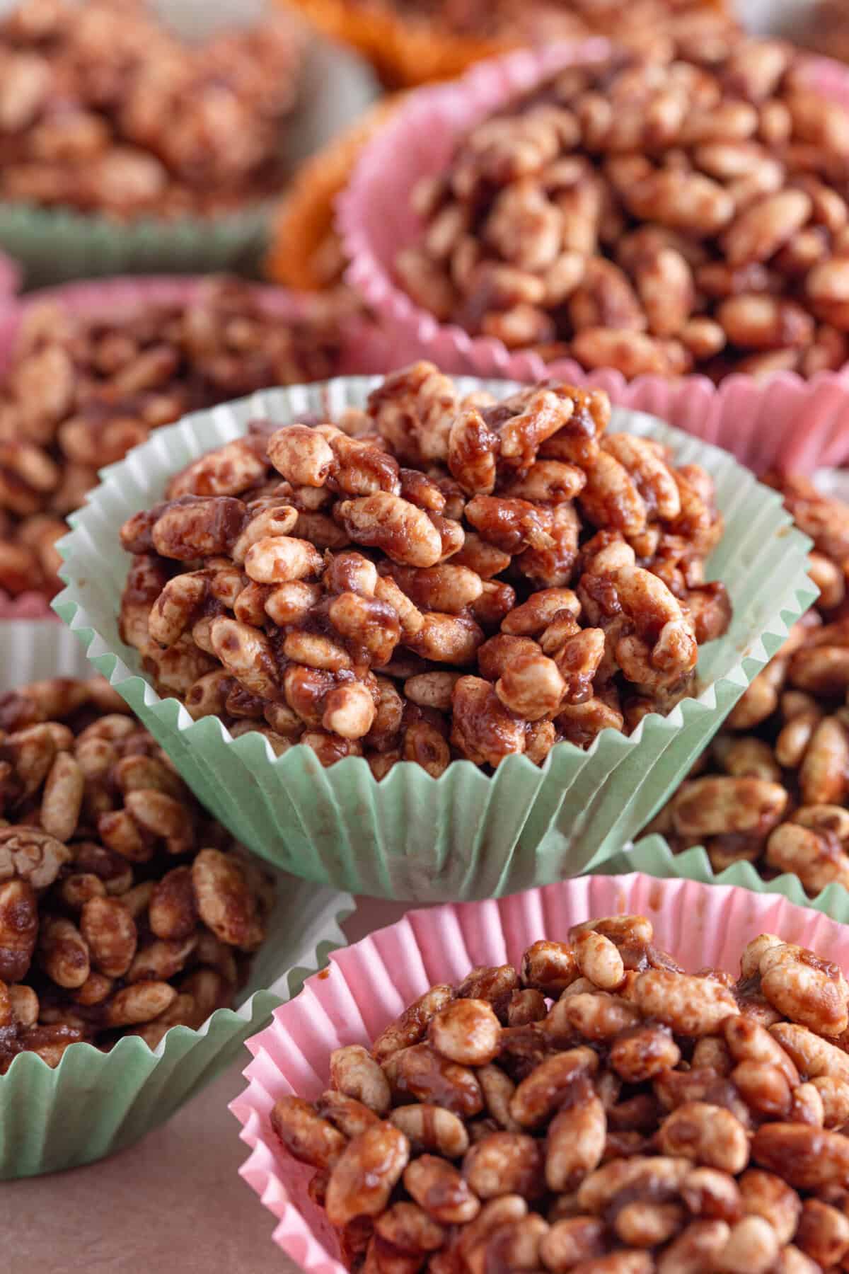 Chocolate rice crispy cakes in pink and green cake cases.