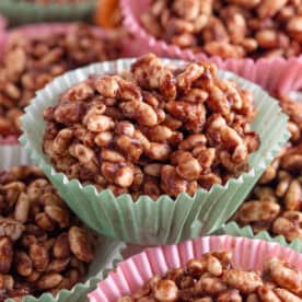 Chocolate rice crispy cakes in pink and green cake cases.