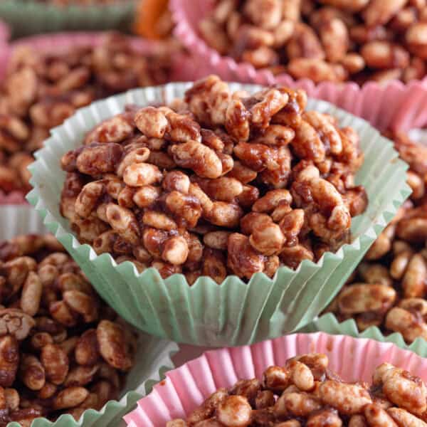 Chocolate rice crispy cakes in pink and green cake cases.