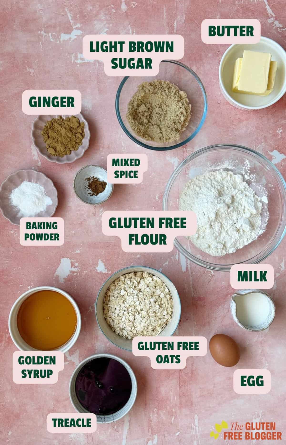 Ingredients for gluten free parkin with labels including oats, syrup, butter, sugar and flour.