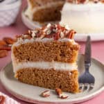 A slice of gluten free pumpkin spice latte cake with the rest of the cake behind.