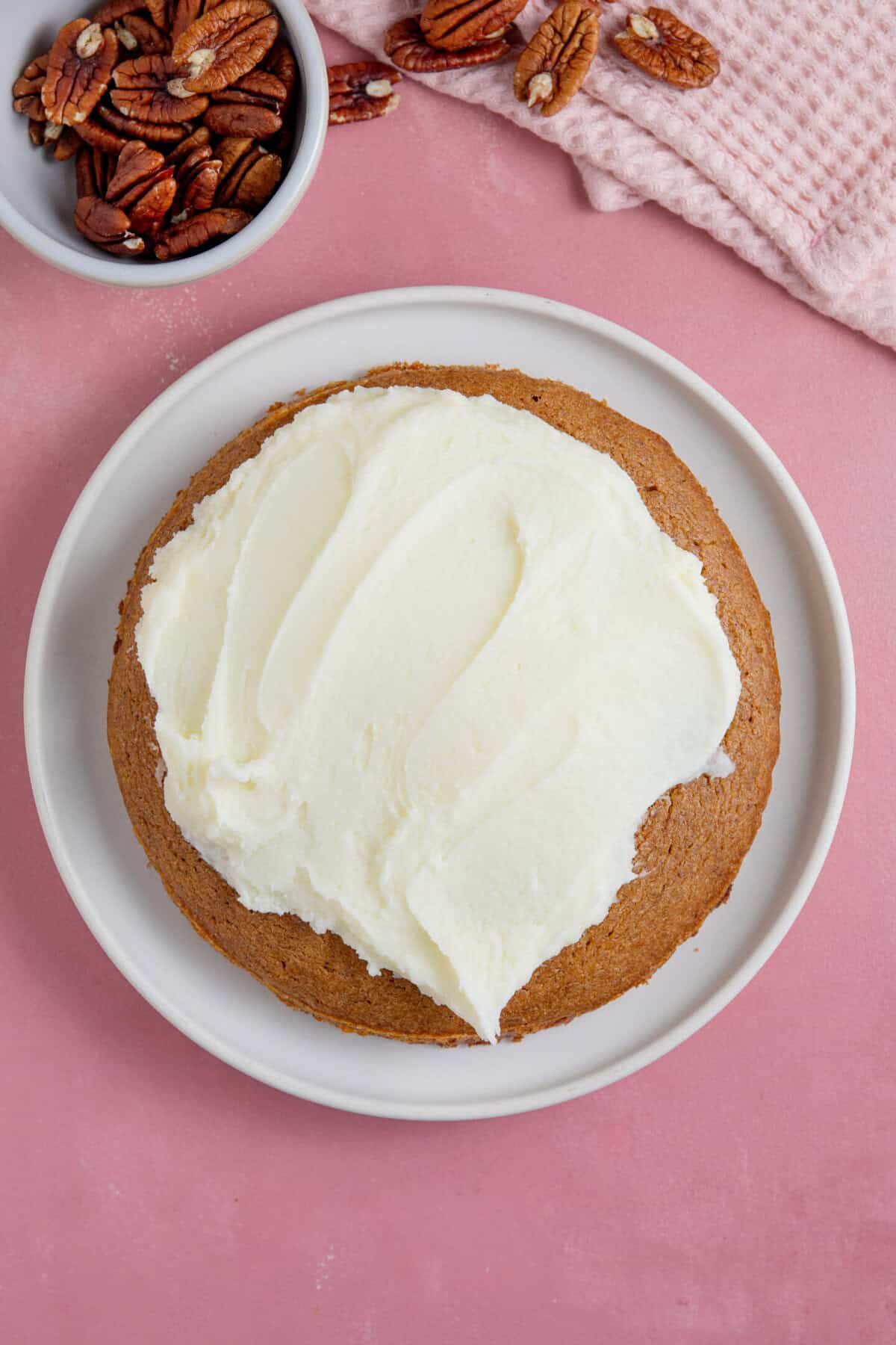 Process shot for a pumpkin spice latte cake showing the cake being constructed with the cream cheese frosting.