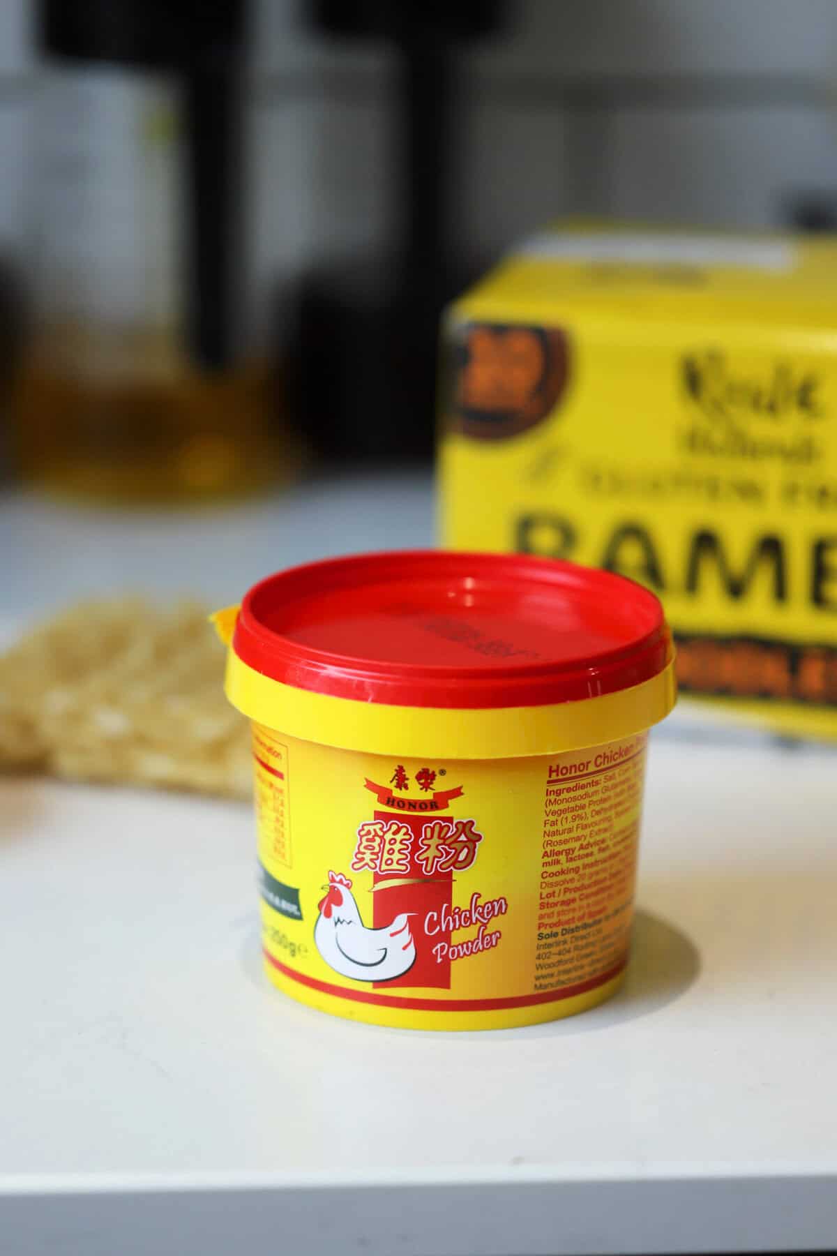 A tub of Honor Chicken Powder on a worktop.