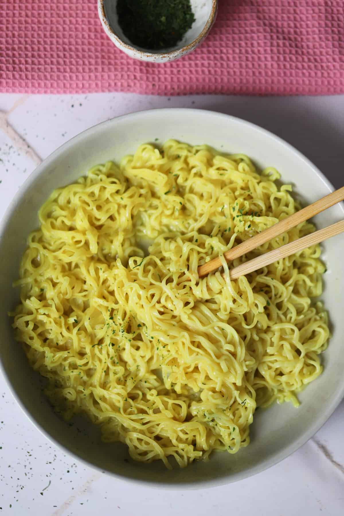 A bowl of gluten free chicken super noodles with chopsticks.