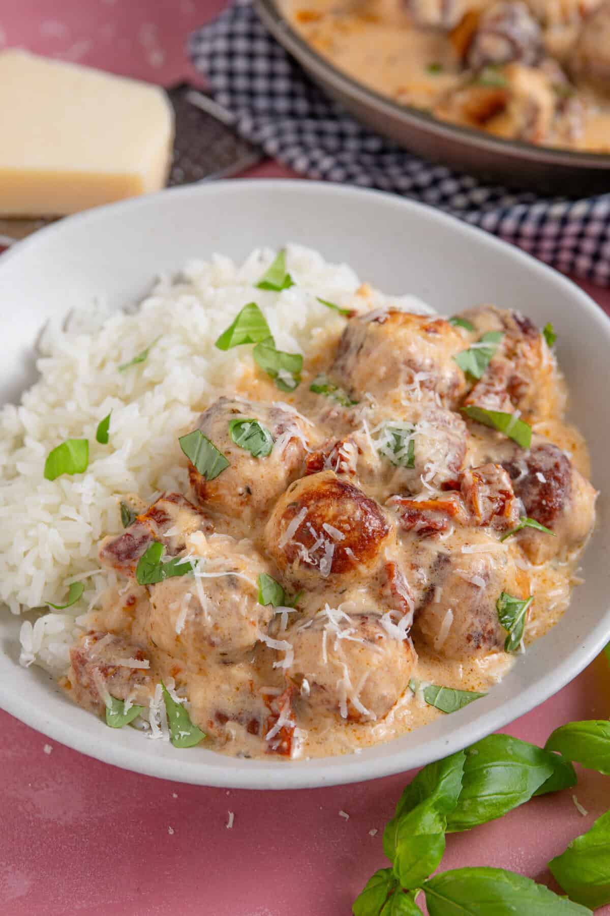 A bowl of Marry Me Chicken Meatballs served up with rice, fresh basil and parmesan.
