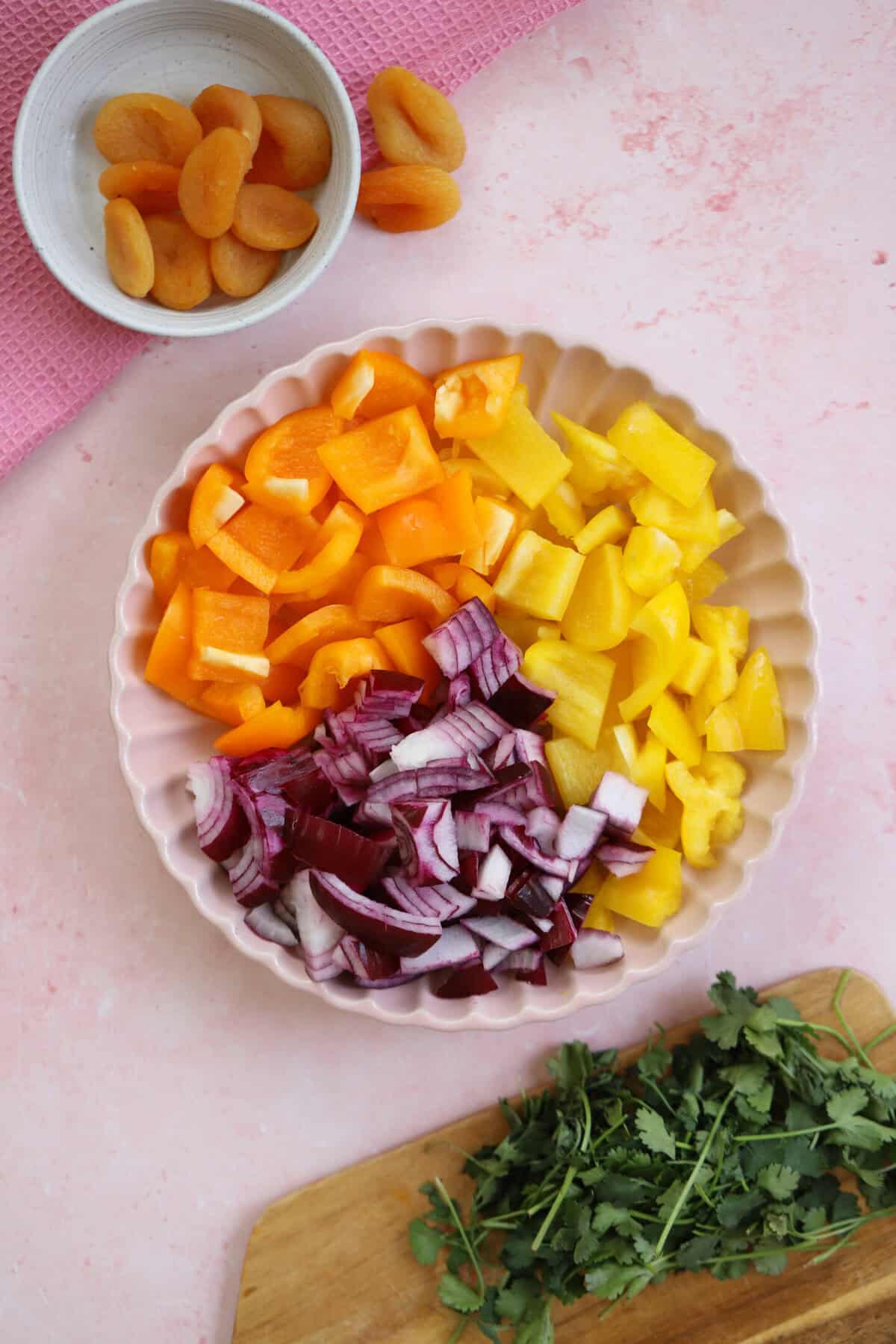 Process shot for slow cooker chicken tagine showing the chopped peppers and onion in a bowl.