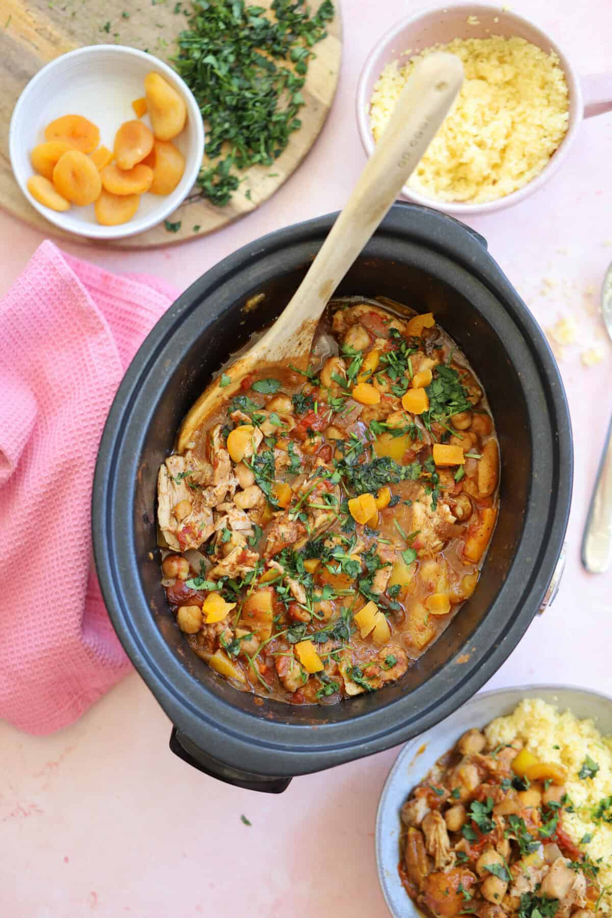 A slow cooker filled with chicken tagine and sprinkled with fresh coriander.