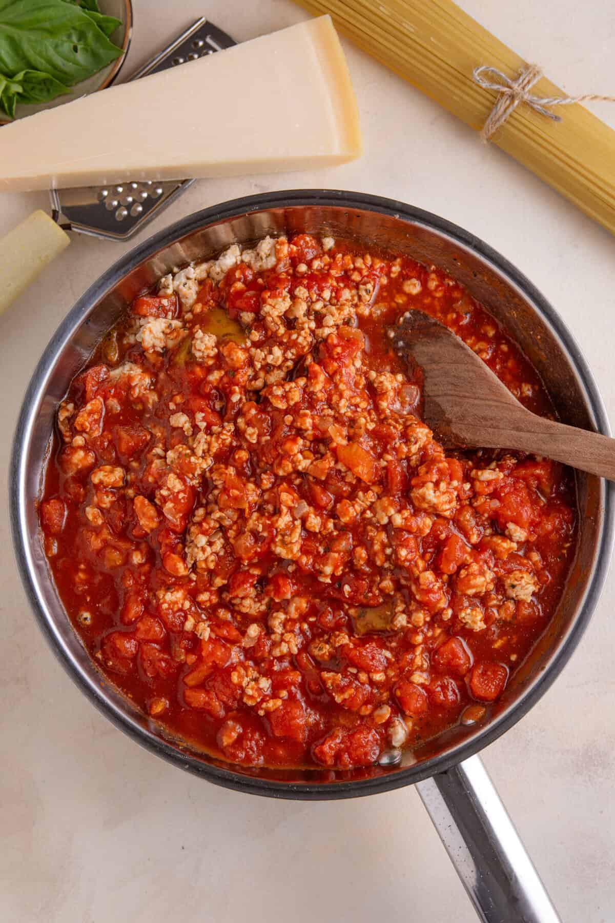 Process shot for turkey bolgonese recipe showing the tomatoes added to the turkey mince.