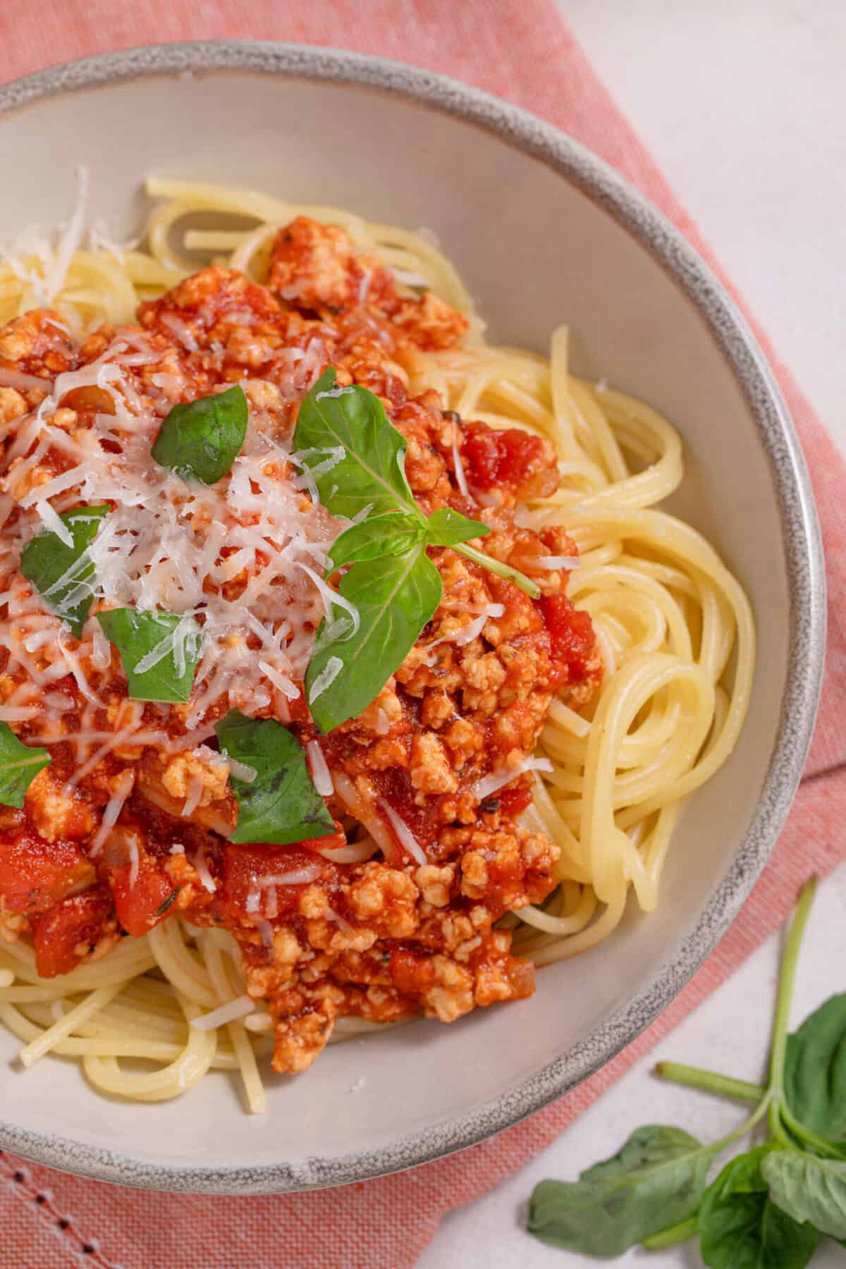 A bowl of turkey bolognese sauce served on top of gluten fre4e spaghetti.