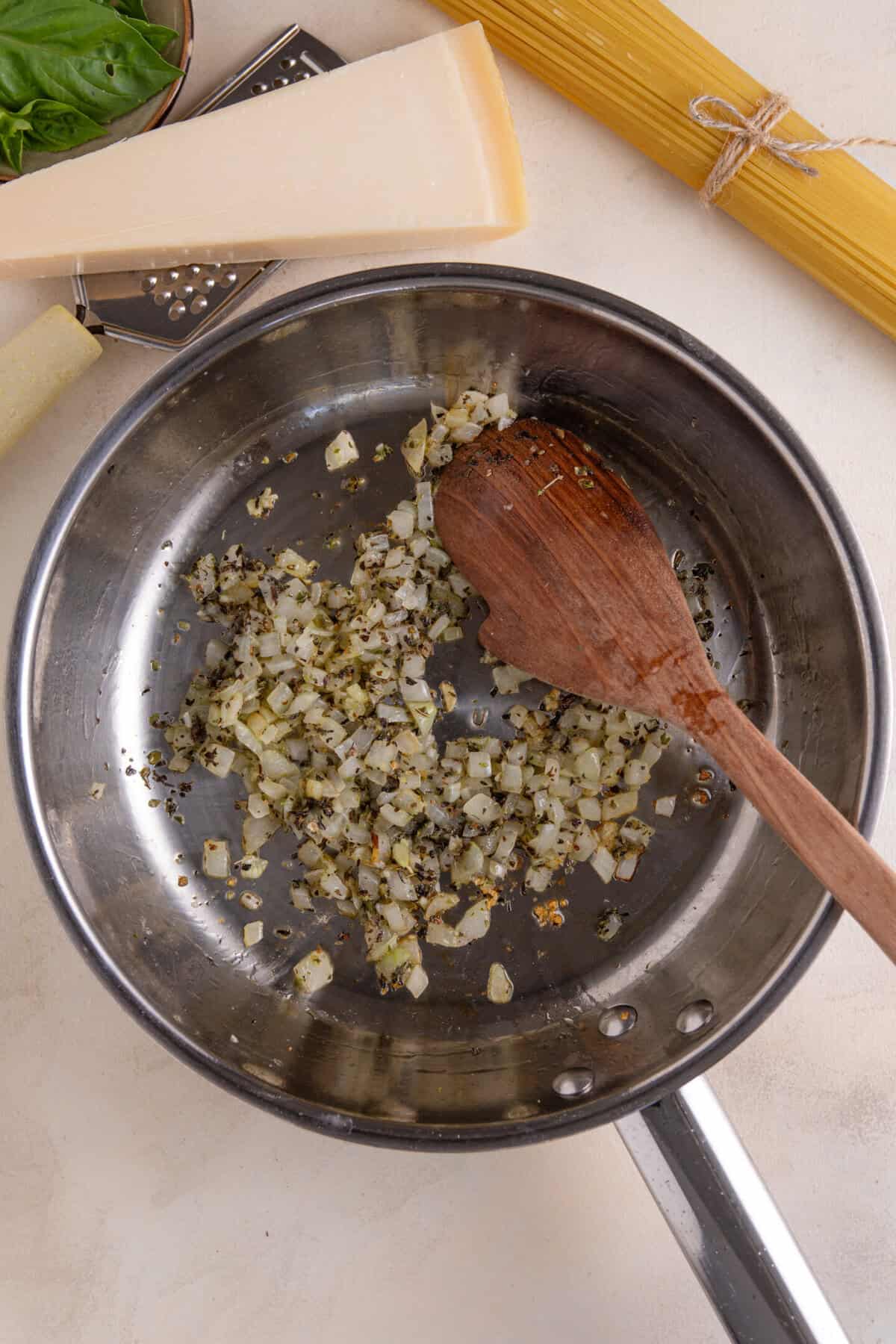 Process shot for turkey bolgonese recipe showing the onion and garlic frying in a pan.
